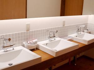 a bathroom with two sinks and a mirror at Yukinoura Guest House Moritaya in Saikai