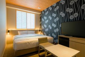 a hotel room with a bed and a television at Tosei Hotel Cocone Kamakura in Kamakura