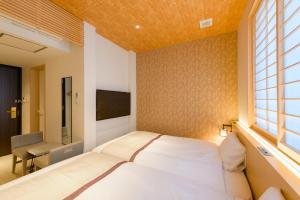 a bedroom with a bed and a window at Tosei Hotel Cocone Kamakura in Kamakura
