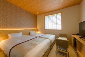 a bedroom with a large bed and a television at Tosei Hotel Cocone Kamakura in Kamakura