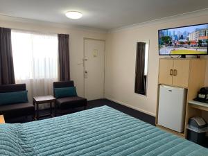 a hotel room with a bed and a desk at Silo Motor Inn Biloela in Biloela
