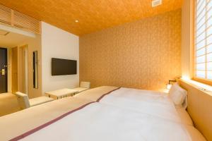 a bedroom with a large bed and a tv at Tosei Hotel Cocone Kamakura in Kamakura