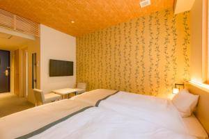 a hotel room with a bed and a tv at Tosei Hotel Cocone Kamakura in Kamakura