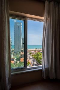 una ventana con vistas al océano desde una habitación de hotel en Fortaleza Mar Hotel, en Fortaleza