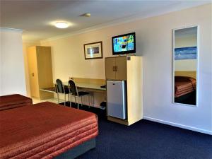 a hotel room with a bed and a television at Silo Motor Inn Biloela in Biloela