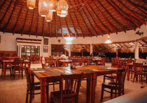 um restaurante com uma grande mesa de madeira e cadeiras em Dos Mundos Pacific Resort em Monterrico