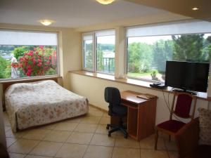 a bedroom with a desk and a bed and a television at Family in Kaunas