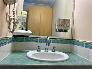 a bathroom with a sink and a mirror at Silo Motor Inn Biloela in Biloela