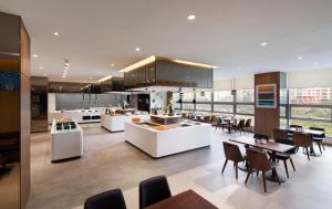 a large kitchen and dining room with tables and chairs at Wirye Militopia Hotel in Seongnam