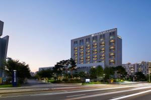 a tall building on a city street with a road at Wirye Militopia Hotel in Seongnam