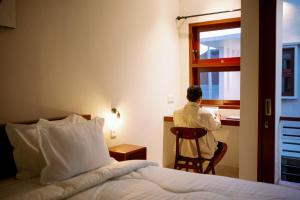 a man sitting at a desk in a hotel room looking out the window at Musa Canggu in Canggu