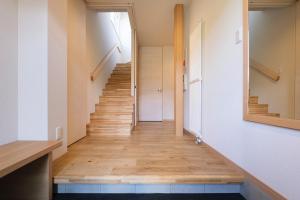 a staircase in a house with wooden floors and a mirror at Furano Sanso in Furano