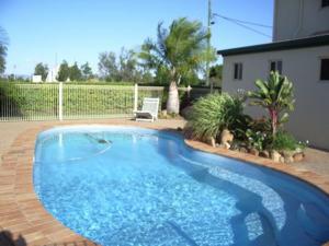 une grande piscine bleue dans une cour dans l'établissement Silo Motor Inn Biloela, à Biloela