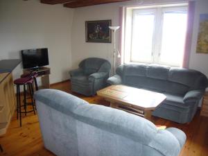 a living room with a blue couch and two chairs at Family in Kaunas