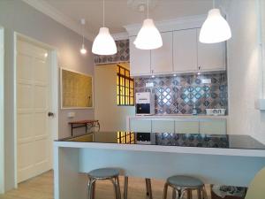 uma cozinha com um balcão e bancos num quarto em Fastbook Sun Moon City Home 12Pax em Ayer Itam
