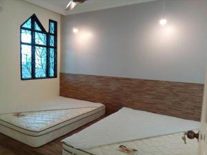 a room with two beds and a window at Fastbook Sun Moon City Home 12Pax in Ayer Itam