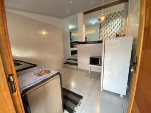 a small kitchen with a refrigerator and a microwave at Chalé Aconchego 1 in Ilhabela