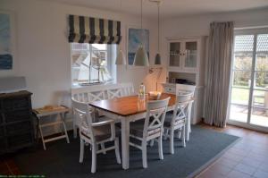 uma sala de jantar com uma mesa de madeira e cadeiras em Hüs Neiwoi em Borgsum