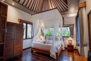 a bedroom with a bed with a canopy at Mangkun Villa Ubud 1 in Ubud +34 photos