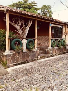 a house with three large tires on the front of it at Hostal Raíces de mi Pueblo in Suchitoto