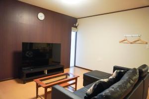 a living room with a couch and a tv and a table at Tiz wan 中田あわじ in Awaji