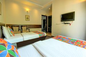 a hotel room with two beds and a flat screen tv at FabHotel Phoenix Hospitality in Gurgaon