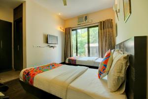 a bedroom with two beds and a window at FabHotel Phoenix Hospitality in Gurgaon