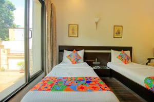a bedroom with two beds and a large window at FabHotel Phoenix Hospitality in Gurgaon