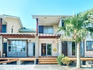 a house with a palm tree in front of it at Mantenbo in Hachijo