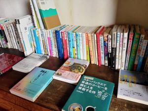 un montón de libros sentados sobre una mesa en 島旅農園ほとり お手紙と農の宿 en Ichii