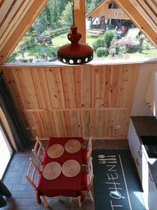 una mesa y sillas en una cocina con ventana en Guesthouse Planinski Dom Majerhold en Solčava