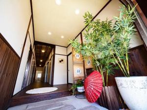 a hallway with plants and a red umbrella at Guest House Zen in Yamanakako
