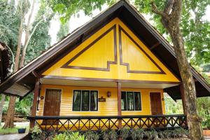 una pequeña casa amarilla con techo negro en Hotel Siblanburi Resort en Mae Hong Son