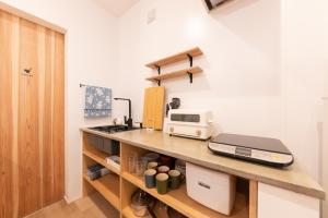 a kitchen with a counter with a microwave and a toaster at 強羅base A棟 - GORA Base A in Gora