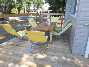 un tavolo e sedie in legno su una terrazza di No 46 Coorie-in a Boat of Garten