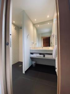 a bathroom with a sink and a large mirror at Les Reflets du Lac in Gérardmer