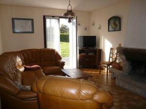 a living room with a leather couch and a fireplace at les volets bleus in Camaret-sur-Mer