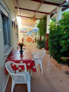 patio con mesa, sillas y parque infantil en Lefteris BEAUTIFUL AEGINA, en Aegina Town