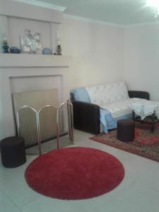 uma sala de estar com um sofá e um tapete vermelho em Nino Apartement Zugdidi em Zugdidi