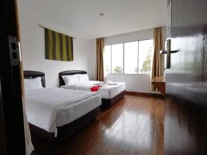 a hotel room with two beds and a window at Ayana Holiday Resort in Kundasang