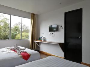 a hotel room with two beds and a window at Ayana Holiday Resort in Kundasang