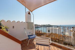 a balcony with two chairs and a view of the ocean at Habitacions Bellaire Cadaqués in Cadaqués