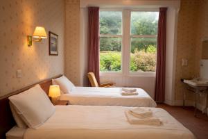 a hotel room with two beds and a window at The Stromness Hotel in Stromness