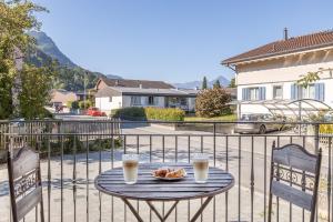 uma mesa com um prato de comida e duas chávenas de café em Ahorn em Interlaken