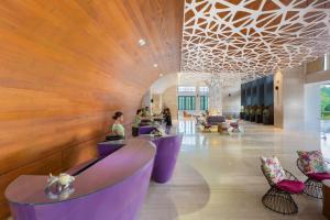 a lobby with purple furniture and a wooden wall at Savoy Hotel Boracay Newcoast in Boracay