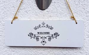 a sign that says welcome hanging on a wall at Muemling Apartments in Erbach