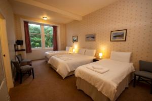 um quarto de hotel com duas camas e uma janela em The Stromness Hotel em Stromness