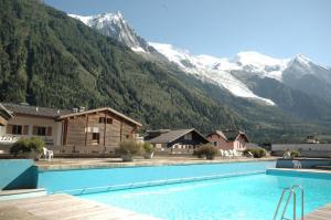 een groot zwembad met bergen op de achtergrond bij Le Beausite C Apartment - Chamonix All Year in Chamonix-Mont-Blanc