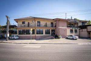 a building with two cars parked in front of it at Penzion Toscana in Nitra