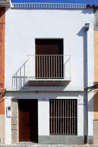 un edificio blanco con balcón en la parte superior en Casa Rural Cal Saboner, en Les Coves de Vinroma